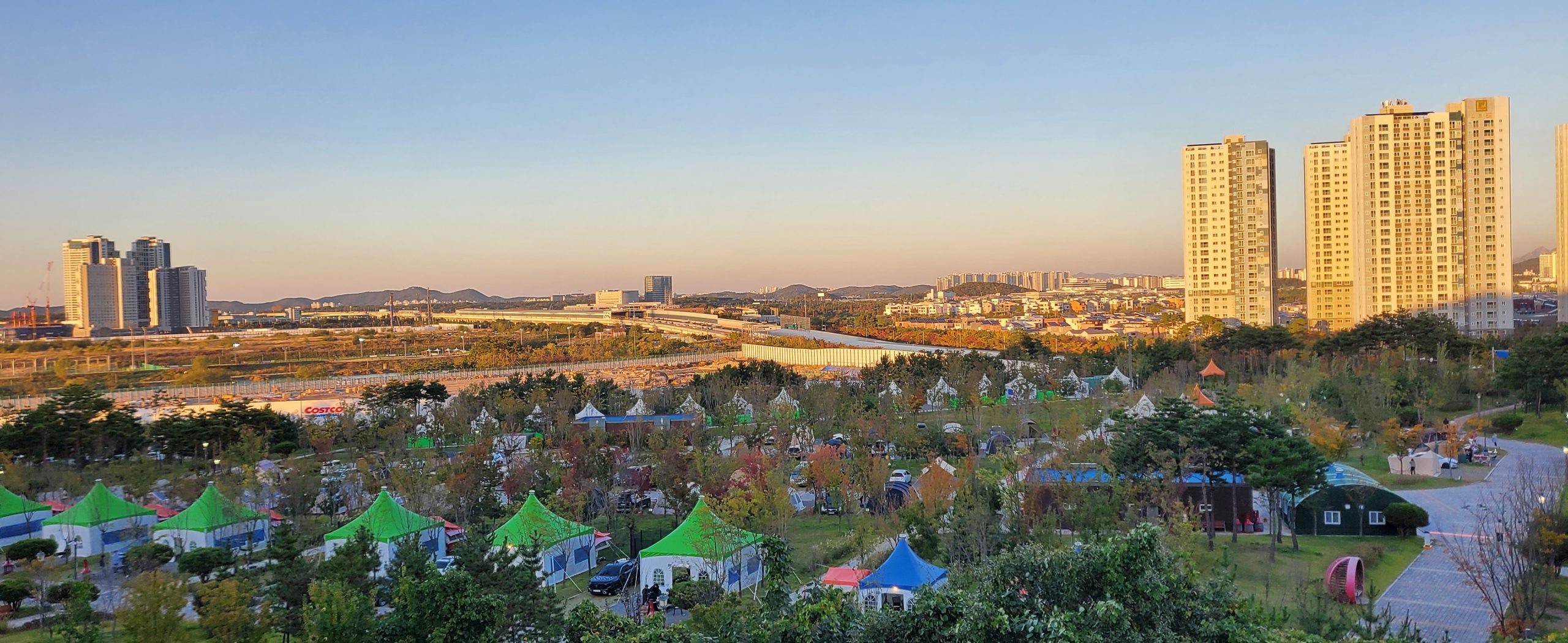 Cheongna Camping Park at sunset with the Incheon city skyline behind