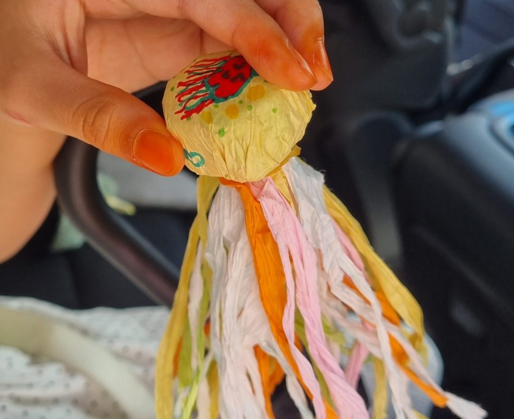 A handmade Korean paper jegi with colorful streamers and a face drawn on it
