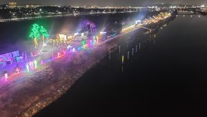 A neon light display along the Ara Waterway reflected in the canal at night