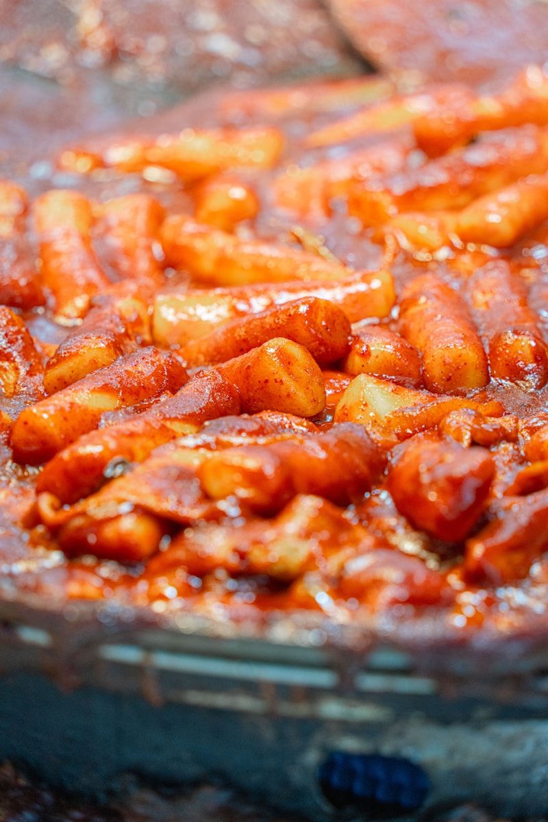 Korean tteokbokki simmers in a spicy sauce.