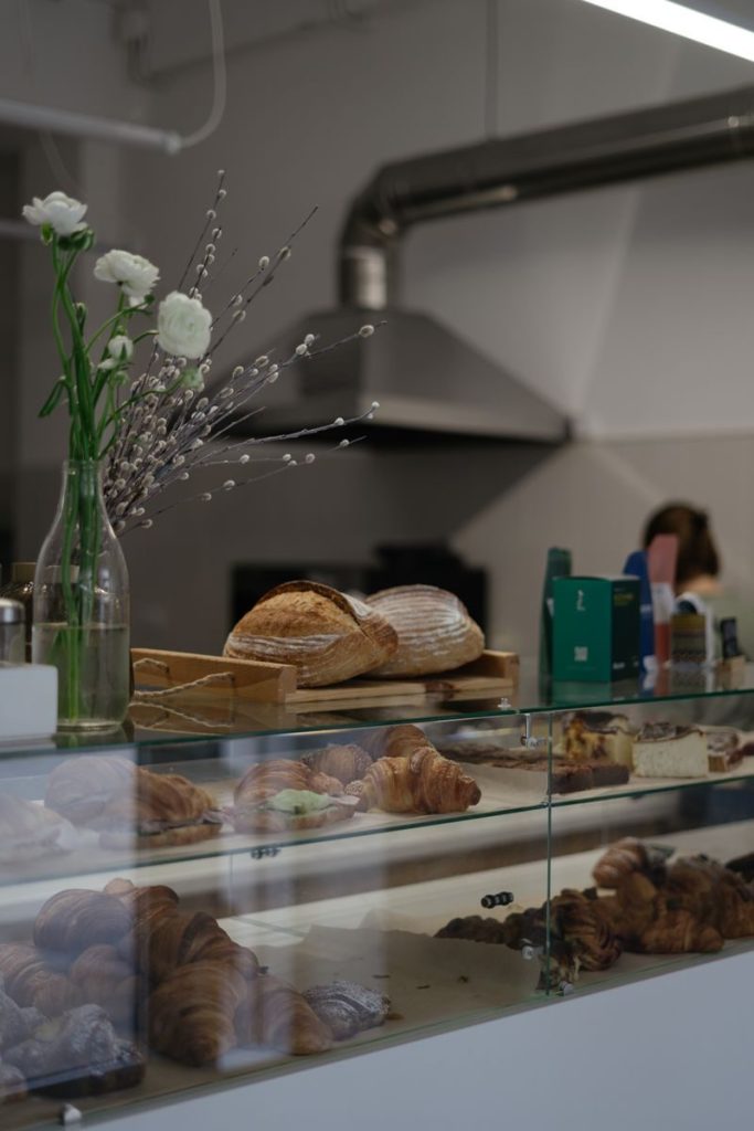 Glass display counter filled with pastries and bread at a cafe