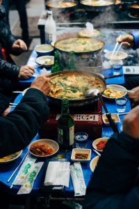 A group sharing a meal at a table with communal dishes