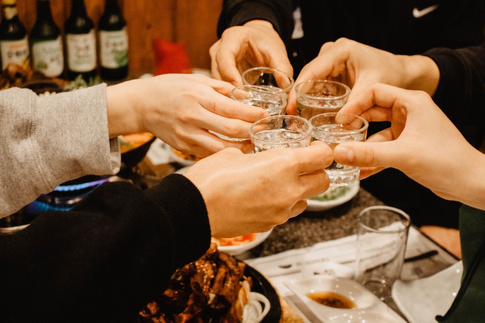 Small glasses and a green bottle on a restaurant table