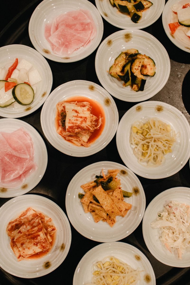 Several small dishes of vegetables and kimchi arranged on a table