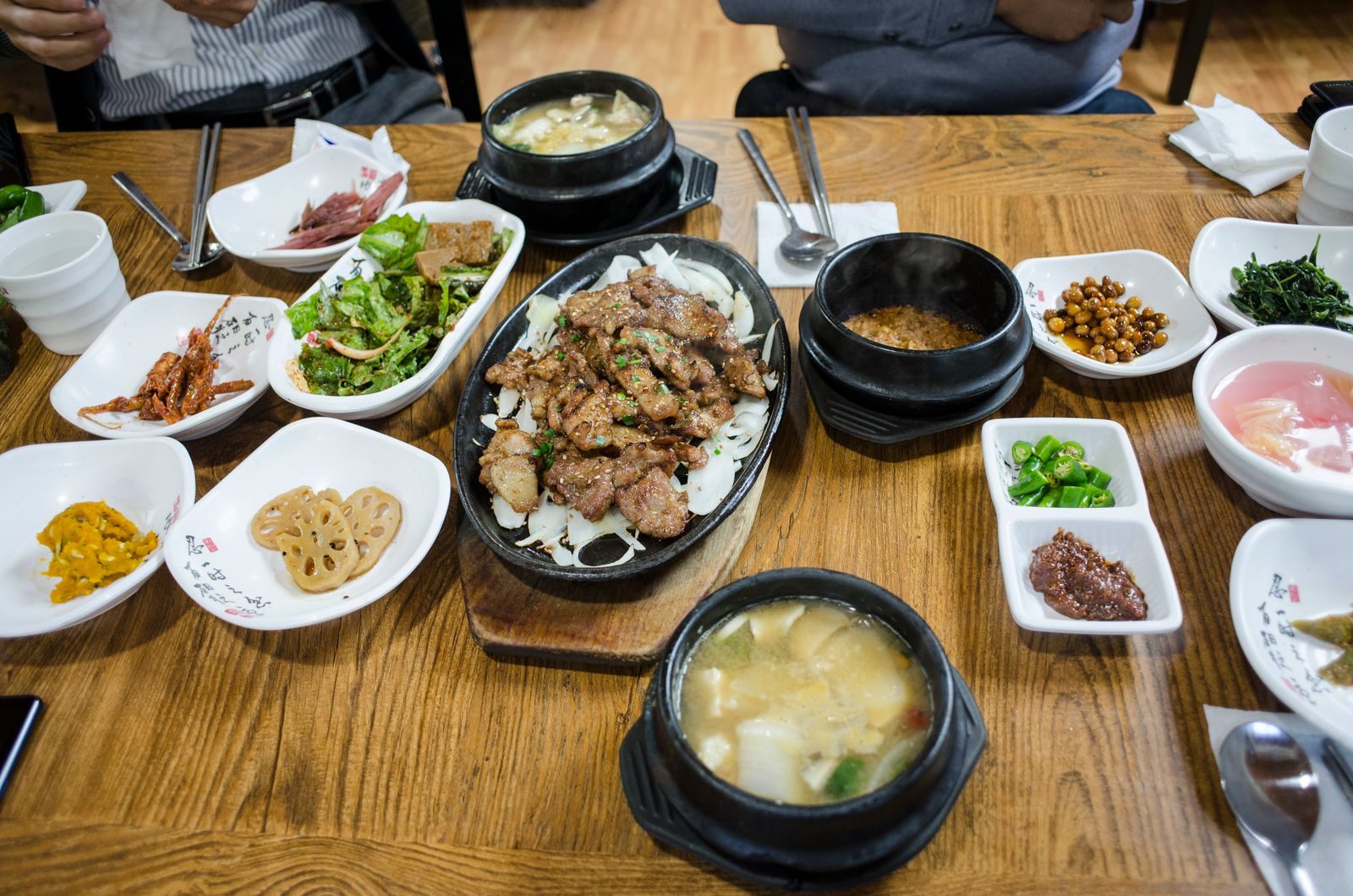 A Korean meal spread across a table with rice, soup, and many small side dishes