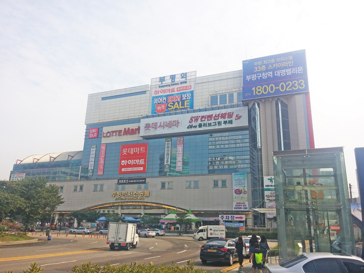 Large station building with a shopping mall, cinema, and supermarket above the platforms