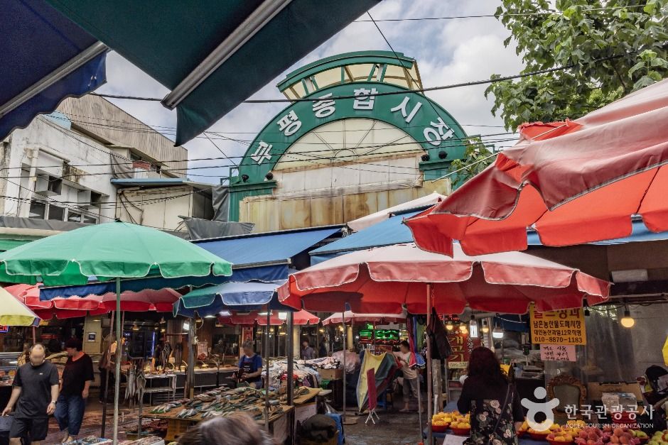 Traditional market entrance arch surrounded by colorful parasols and produce stalls