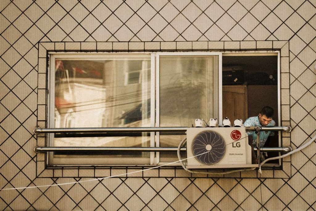 An air conditioning unit mounted outside a residential building in Korea