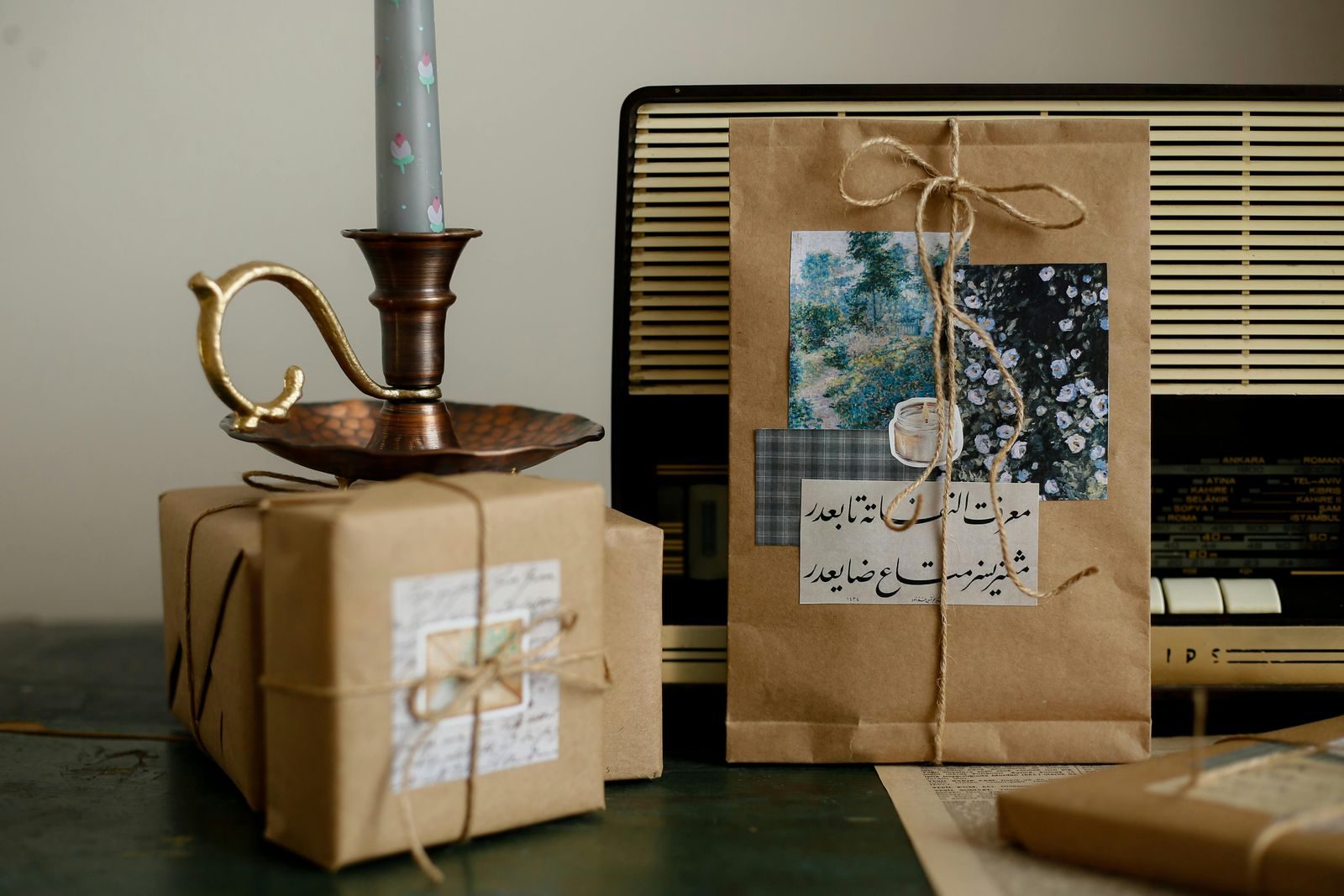 Rustic brown paper wrapped gifts with a vintage radio and candle holder create a nostalgic atmosphere.