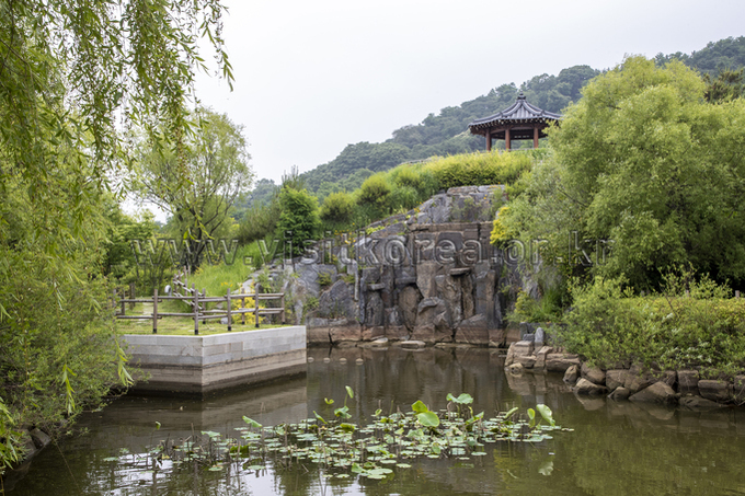A pavilion shelter in Wolmi Park comes into view, with a pond located below it.