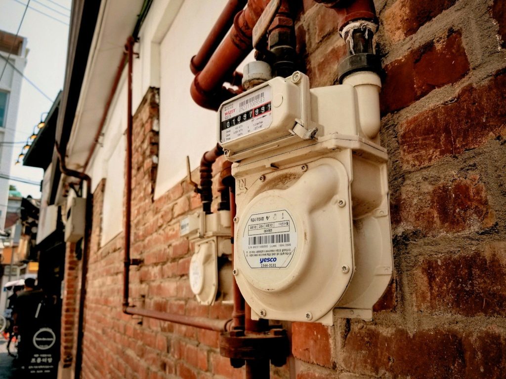 A utility meter mounted on the exterior wall of a Korean house