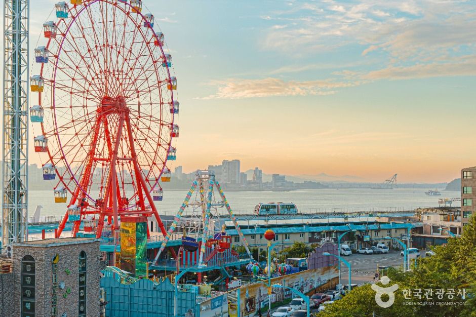 Ferris wheel and fairground rides on the Wolmido seafront at sunset