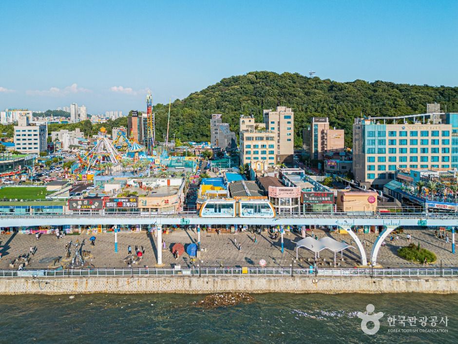 Aerial view of Wolmido Incheon showing the amusement strip and seafront with a wooded hill rising behind