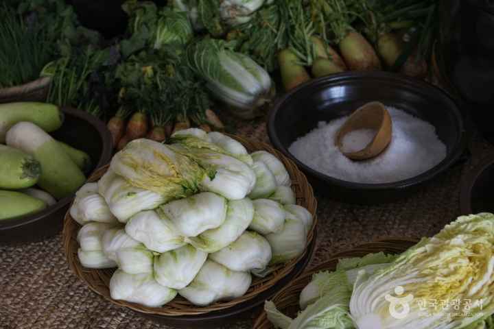 The prepared napa cabbage, coarse salt, and ponytail radishes are laid out, ready for making kimchi.